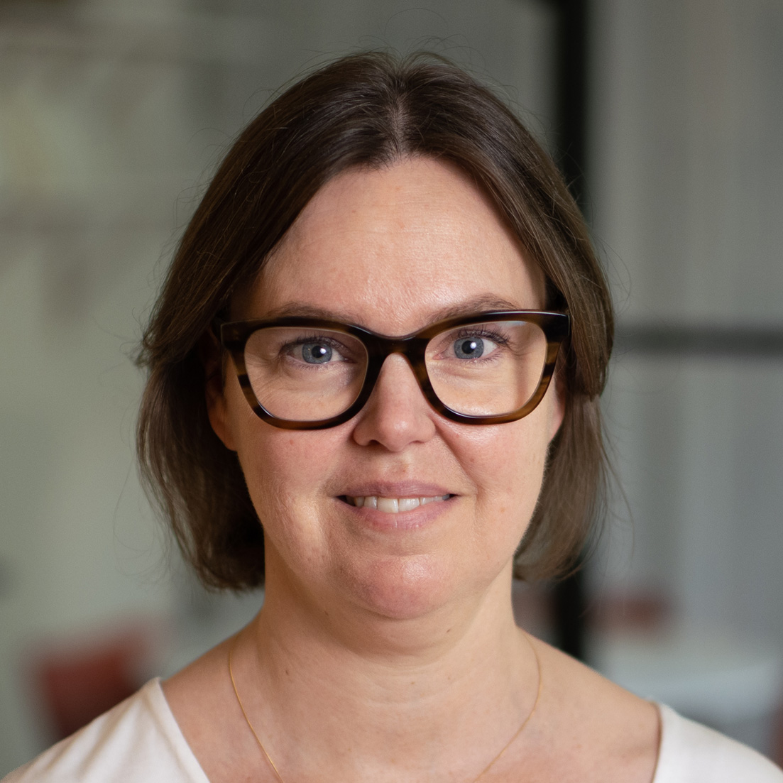 Porträttbild på Kristina med glasögon. Fotograf Henrik Skarstedt